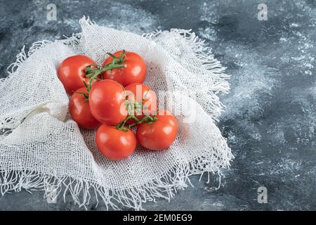 Alcuni pomodori succosi su un panno di sackcloth bianco Foto Stock