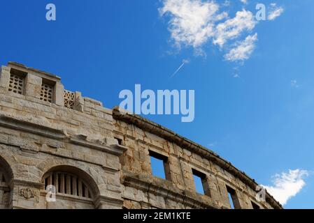 Contrada del jet plane sopra l'antico anfiteatro romano a Pola, Croazia Foto Stock