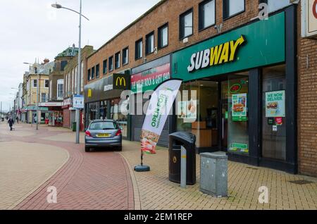 Rhyl, Denbighshire; Regno Unito: 21 febbraio 2021: Una scena generale di High Street in un pomeriggio di domenica durante il blocco pandemico. La metropolitana è aperta per prendere Foto Stock