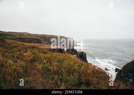 Vista panoramica delle scogliere e del mare contro il cielo nuvoloso un giorno tempestoso a Pointe Saint Mathieu, Bretagna, Francia Foto Stock