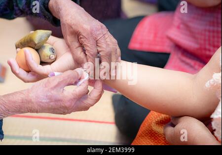 La cerimonia di legare il polso della gente con il filo santo per consolare il Kwan della gente. Cultura tailandese. Credenze e cultura locale della Thailandia nordorientale. Foto Stock