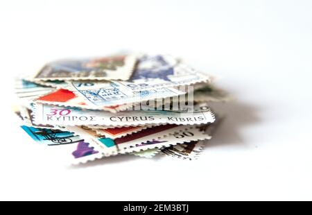 Pila di francobolli isolati su sfondo bianco Foto Stock