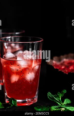 Composizione sorprendente con cheesecake alla fragola e bevanda alla fragola con rosmarino. Solo una parte della cheesecake a fuoco e una particella di un bicchiere di d Foto Stock