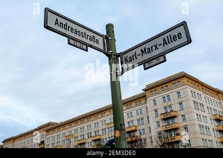 Berlino, Germania. Via Nome segno di Karl Marx Allee e Andreasstrasse di fronte a edifici di costruzione anni '50. Foto Stock