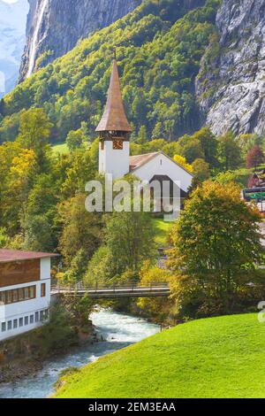 Vista autunnale della torre della chiesa di Lauterbrunnen e cascata delle cascate Staubbach, Alpi svizzere, Svizzera Foto Stock