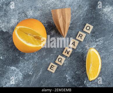 Frutta arancione tagliata con alesatore di legno Foto Stock