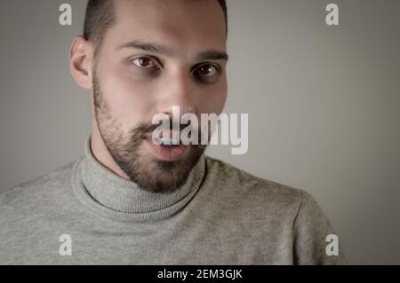 Ritratto di un giovane con una barba corta che sembra sorpreso Foto Stock
