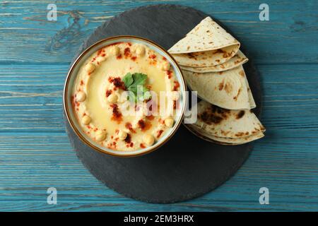 Vassoio con ciotola di hummus e pita su fondo di legno Foto Stock