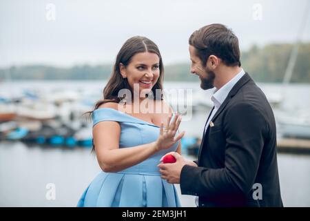 Uomo gioioso che propone e acconsente bella donna Foto Stock