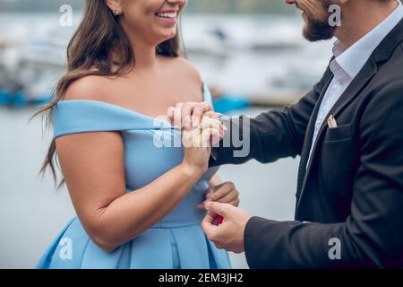 Uomo che mette l'anello di nozze sul dito di womans Foto Stock