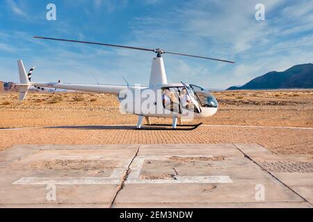 Sossusvlei, Namibia - 26 agosto 2016. Un elicottero turistico si siede a terra mentre il pilota si prepara a partire per un volo sopra il deserto del Namib. Foto Stock