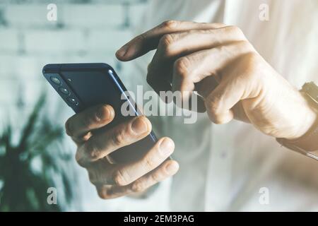 uomo d'affari che usa lo smartphone in ufficio. primo piano Foto Stock