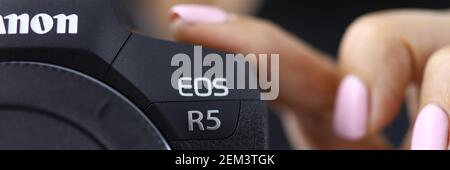 Mano femmina che tiene una fotocamera canon eos r5 primo piano Foto Stock