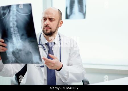 Il medico curante sta indicando un radiografia del suo paziente . Foto Stock