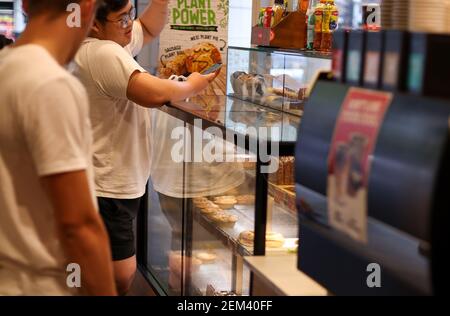 Sydney, Australia. 24 Feb 2021. La gente compra le torte di carne ad un negozio di torta di carne a Sydney, Australia, 24 febbraio 2021. Una torta australiana di carne è una torta a misura di mano che contiene carne e sugo a dadini o tritati, a volte con cipolla, funghi o formaggio, e spesso consumata come spuntino da asporto. Credit: Bai Xuefei/Xinhua/Alamy Live News Foto Stock