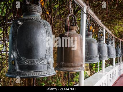 Una fila di vecchie campane Sacrali in acciaio al Tempio del Monte d'Oro (Wat Saket) a Bangkok, Thailandia Foto Stock
