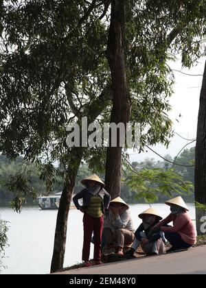 Una vista delle donne nei cappelli tradizionali Vietmanesi fuori di un tempio nel complesso di Thien Mu Pagoda a Hue, Vietnam. Da una serie di foto di viaggio scattate in VI Foto Stock