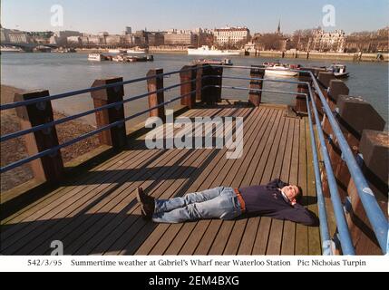 Un uomo che si approssima nel sole primaverile di Gabriels Wharf sulla South Bank a Londra Foto Stock