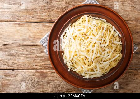 Gustosi spaghetti italiani Cacio e Pepe nel piatto sul tavolo. Vista orizzontale dall'alto Foto Stock