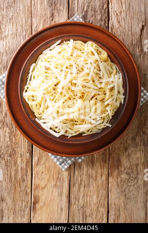 Spaghetti Cacio e Pepe Ricetta primo piano nel piatto sul tavolo. Vista dall'alto verticale Foto Stock