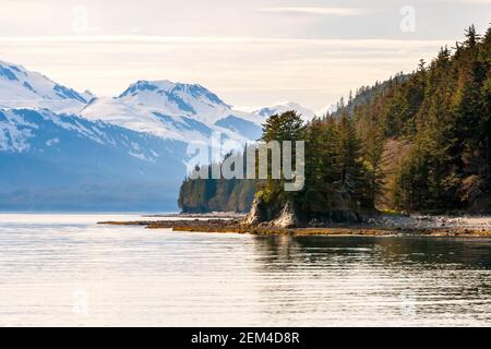 Montagne innevate e alberi sempreverdi lungo la costa del sud Alaska Foto Stock