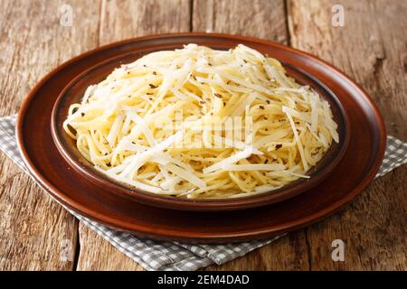 La pasta fatta in casa Cacio e pepe è il mac originale e la chioccia di formaggio nel piatto sul tavolo. Orizzontale Foto Stock