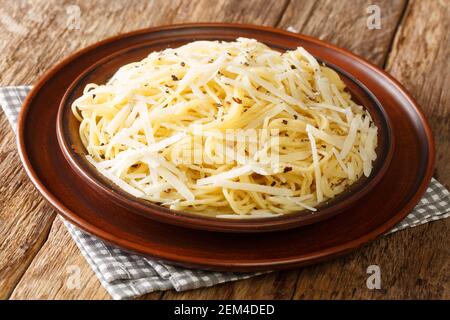 Il cacio e Pepe è un piatto di pasta romana che si traduce in formaggio e pepe in primo piano nel piatto sul tavolo. Orizzontale Foto Stock