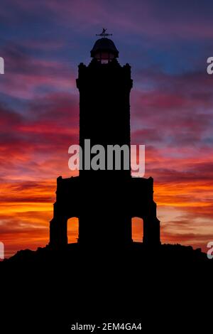 Alba alla Darwen Tower (Jubbliee Tower) - una silhouette della torre con profondo cielo rosso Foto Stock