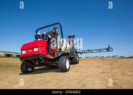 Un greenkeeper che usa un moderno spruzzatore sul campo da golf Foto Stock