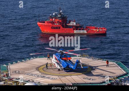 Un elicottero Sikorsky S-92 sull'eliporto su un impianto offshore di petrolio e gas nel Mare del Nord. È possibile vedere anche un'imbarcazione in standby Foto Stock