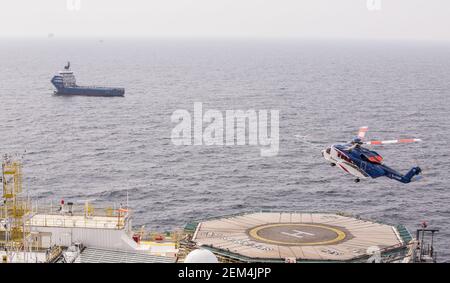 Un elicottero Sikorsky S-92 arriva a terra sull'eliporto su un impianto offshore di petrolio e gas nel Mare del Nord. È visibile un serbatoio di alimentazione Foto Stock