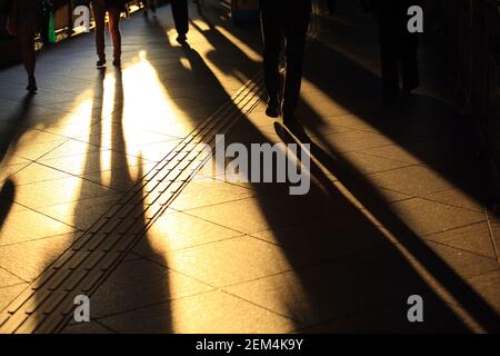 Scene urbane: l'ombra del movimento della camminata, pedonale in area finanziaria a Hong Kong sotto il sole Foto Stock