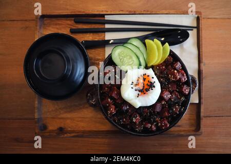 Bistecca di tonno sul riso con uova in stile giapponese su legno vista dall'alto del tavolo Foto Stock