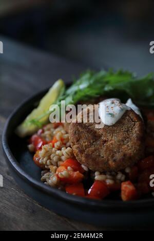 Salmone fishcakes con oat e insalata su un tavolo di legno Foto Stock