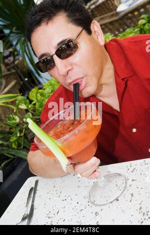 Primo piano di un uomo maturo che beve un cocktail Foto Stock