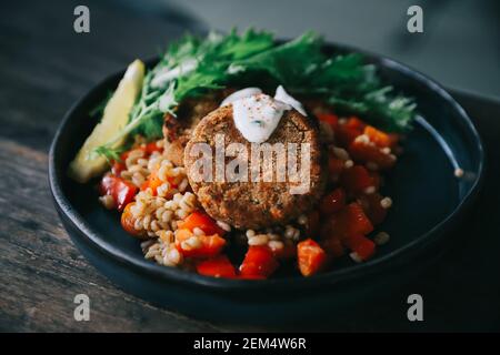 Salmone fishcakes con oat e insalata su un tavolo di legno Foto Stock