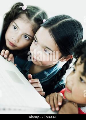 Primo piano di tre ragazze che utilizzano un notebook Foto Stock