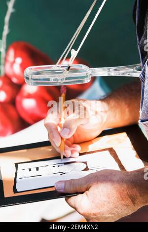 Primo piano delle mani di una persona che disegna uno schizzo su un telaio Foto Stock