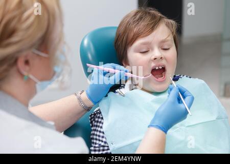 Ragazzo giovane che ottiene il trattamento dentale da dentista professionista Foto Stock