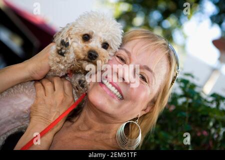 Ritratto di una donna matura che sorride e tiene un cucciolo Foto Stock