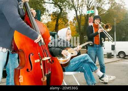 Tre musicisti di strada che suonano Foto Stock