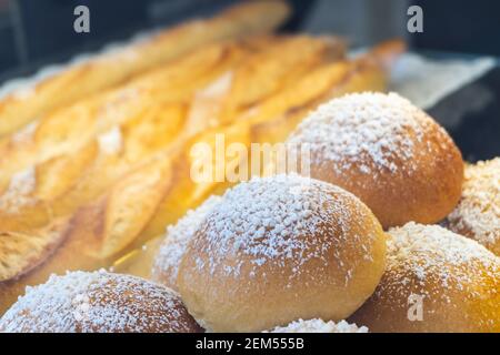Primo piano di panini soffici ricoperti di zucchero in panetteria Foto Stock