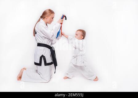 Madre suo figlio piccolo che pratica arti marziali su sfondo bianco. Foto Stock