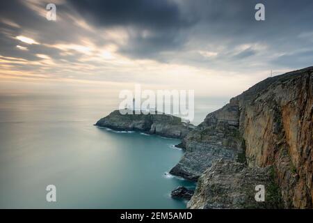 Il faro di South Stack è costruito sulla cima di una piccola isola al largo della costa nord-occidentale di Holy Island, Anglesey, Galles Foto Stock