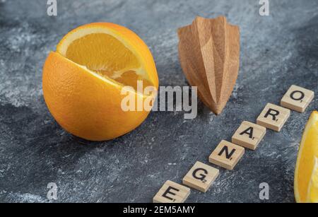 Frutta arancione tagliata con alesatore di legno Foto Stock