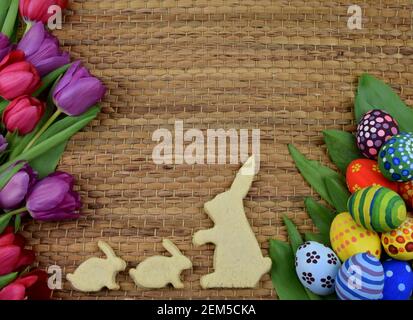 tulipani, primrosi, uova dipinte e biscotti a forma di coniglietto Foto Stock