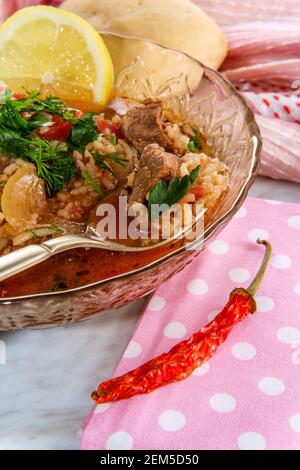 Tradizionale zuppa di manzo Kharcho della Georgia paese servita con un peperone secco e un limone a fette Foto Stock