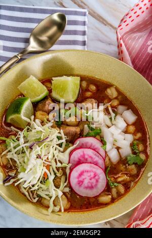 Porco messicano Pozole rojo e stufato di casalinga con varietà di guarnizioni di verdure fresche da guarnire Foto Stock