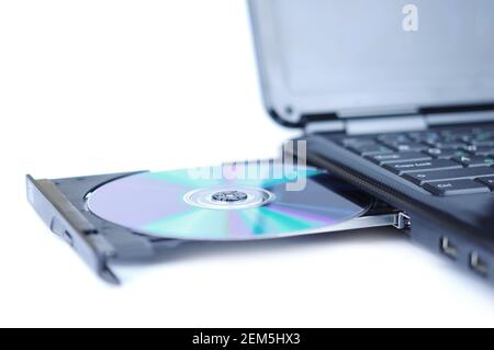 Computer portatile con un DVD su disco nel vassoio Foto Stock