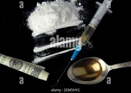Cocaina, denaro, cucchiaio e siringa monouso su fondo nero. Dipendenza da stupefacenti. Foto Stock